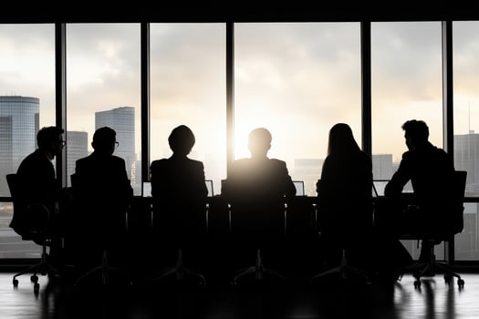 Mixed team in board meeting discusses compliance issues and identifies potential solutions during sunset photo