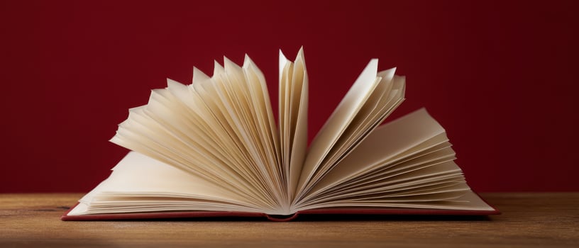 The open book showcasing its pages against a rich red background. photo