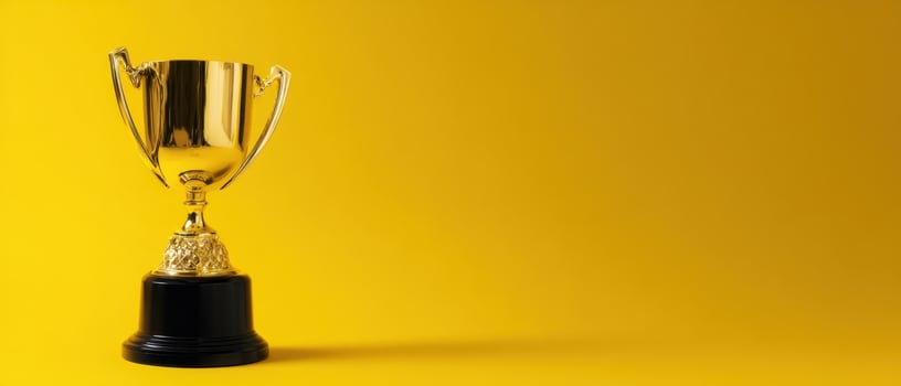 The shining trophy representing victory and success against a vibrant yellow backdrop. photo