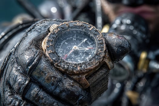 A diver holding a watch with a diving glove photo