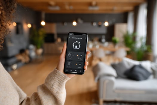 A woman holding a smart home app in a living room photo