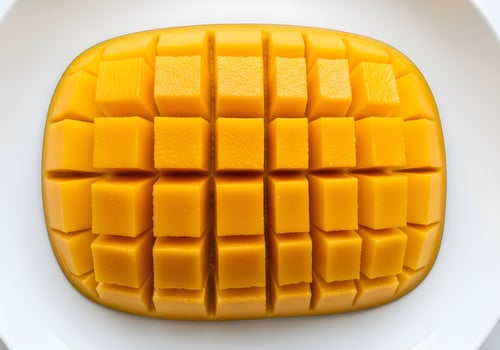 Mango Cubes Arranged on White Plate Overhead photo