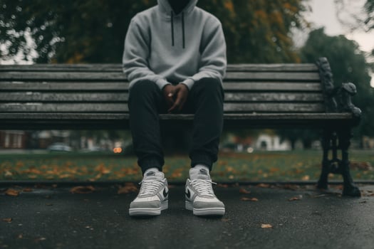 A person sitting on a bench with sneakers photo