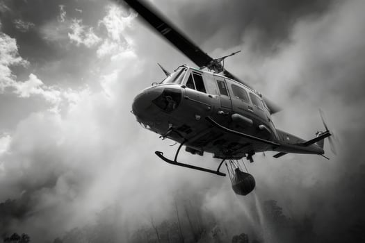 A black and white photo of a helicopter flying through the air