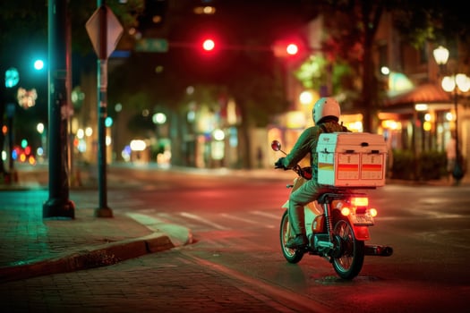A person riding a motorcycle with a box on the back photo