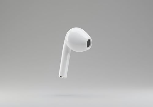 Single White Wireless Earbud on a Simple Gray Studio Background photo