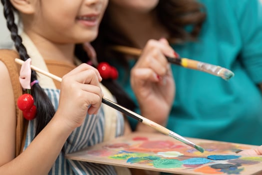Creative bonding. Mother and daughter enjoying painting together at home. photo
