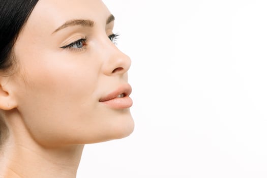 Close-up profile of a woman with clear skin and elegant makeup, showcasing beauty and confidence against a clean white background, emphasizing the essence of modern cosmetology and skincare photo