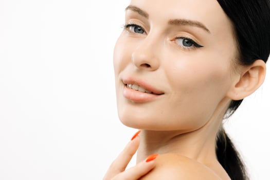 Close-up portrait of a woman with clear skin and natural beauty, showcasing flawless complexion and subtle makeup against a clean white background, emphasizing elegance and confidence with copy space photo