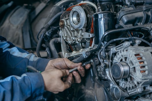 Close up hands of auto mechanic repairs an engine, replacing the timing chain photo