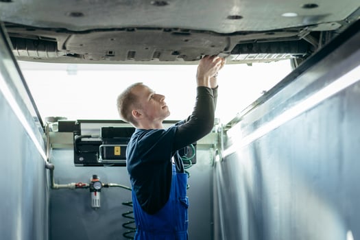 A car mechanic adjusts wheels in a car repair shop, close up photo