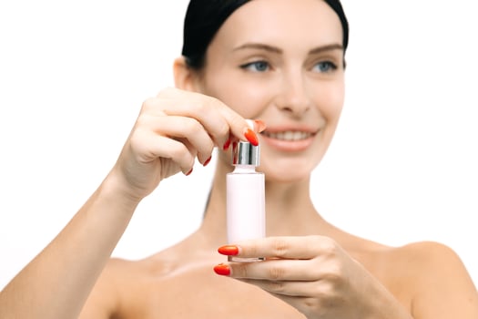 Woman with smooth skin holding a serum bottle, showcasing rejuvenation product, with a bright background emphasizing beauty and skincare, promoting healthy skin and self-care routines photo
