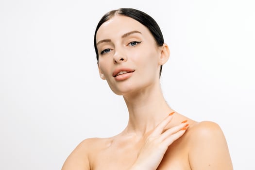 Beautiful woman with clear skin and sleek black hair poses gracefully against a white background, showcasing natural beauty and confidence in a serene and elegant manner photo