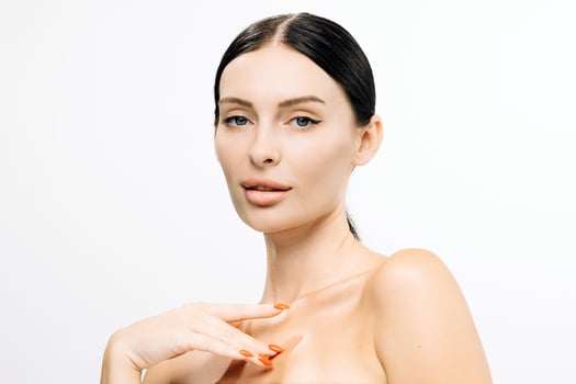 Beautiful woman with clear skin and sleek black hair, showcasing flawless beauty against a white background, emphasizing elegance and confidence in a captivating portrait with copy space photo