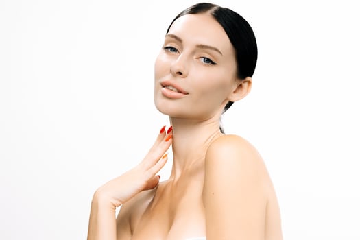 Beautiful woman with clear skin poses gracefully against a white background, showcasing flawless complexion and elegant features, embodying beauty and confidence in a serene atmosphere photo