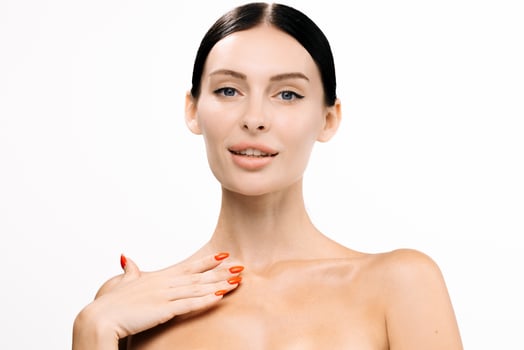 Female model showcasing rejuvenating serum on bare skin, with a soft glow and elegant pose, highlighting beauty and skincare routine in a minimalist setting with bright background photo