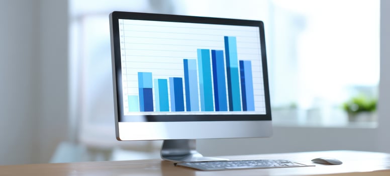 The desktop computer showcasing colorful graphs and data analysis in a bright office setting. photo