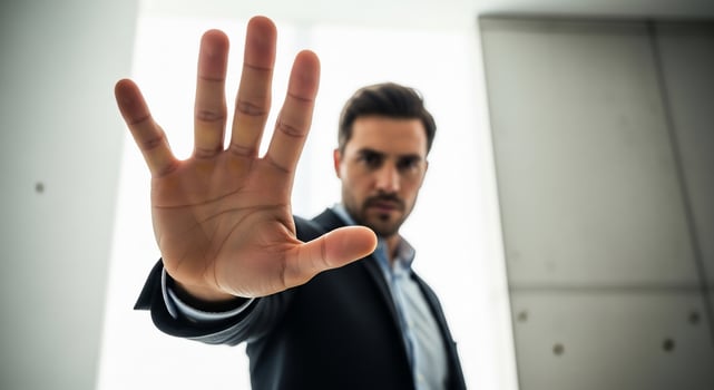 A man in a suit is holding up his hand photo