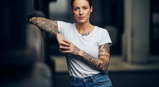 A woman with tattoos leaning against a wall photo