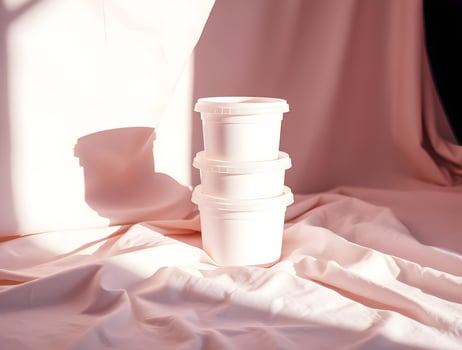 Three white plastic containers sit on a cloth photo