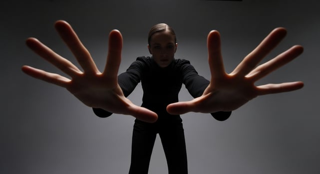 A woman in black suit with hands outstretched photo