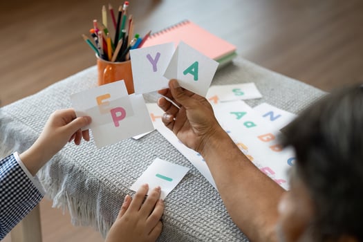 Educational Engagement. Grandfather and child exploring letters with flashcards. photo