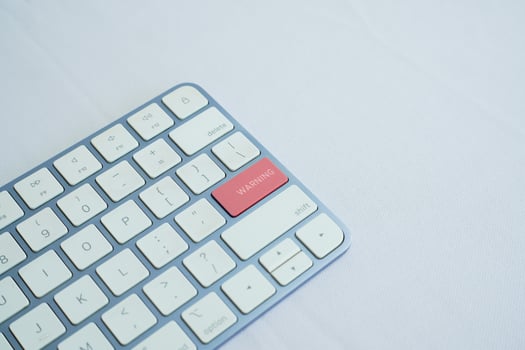 a white keyboard and a red key that says WARNING. Financial and technology concept photo