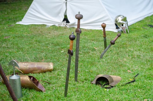 Still life of Roman weapons and armor on a green field. photo