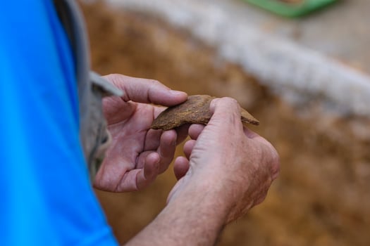 Close-up of a scientist holding a fragment of ancient ceramic. photo