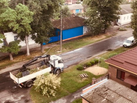 Truck clearing debris on suburban street in summer afternoon photo