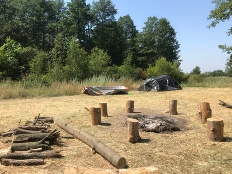 Camp site with a fire pit and tents in the woods photo