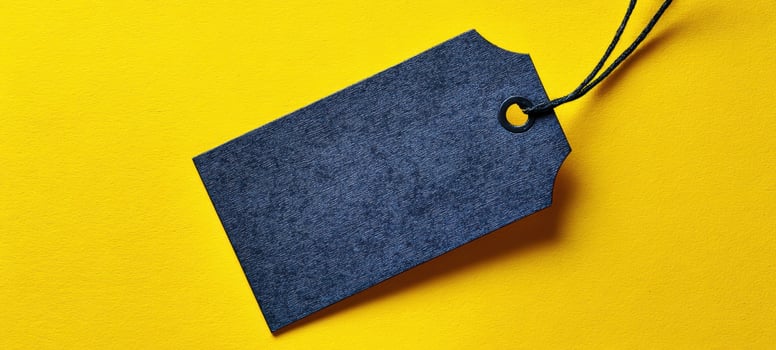 The blank black tag on a bright yellow background for creative design purposes photo