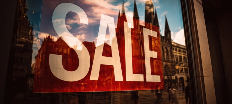 The vibrant SALE sign reflecting in the urban storefront window. photo