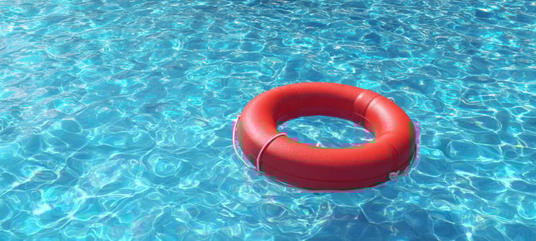 The vibrant red lifebuoy floating in a clear blue swimming pool. photo