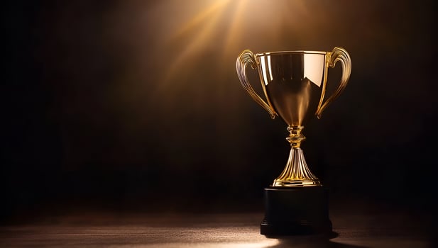 Golden Trophy Cup Illuminated by Spotlight on Dark Background photo