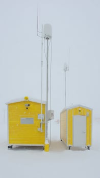 Bright Yellow Buildings Stand Out Against Snowy Arctic Landscape. photo
