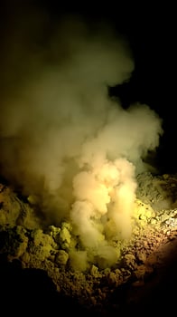 Raw Power of Nature Yellow Smoke and Rocky Terrain at Night. photo