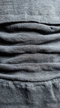 Detailed Close Up Texture of Dark Grey Fabric with Deep Folds. photo