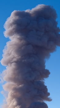 Massive Dark Smoke Plume Against a Clear Blue Sky. photo
