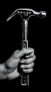 Woman's Hand Holding Hammer with Nailed It Written. photo