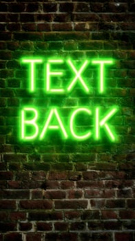 Neon Green Text Back Sign Glowing on an Old Brick Wall. photo