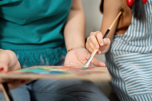 Collaborative art. Mother and daughter painting together with vibrant colors. photo