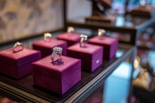 Jewelry display case featuring elegantly designed rings on soft velvet stands in a retail setting photo