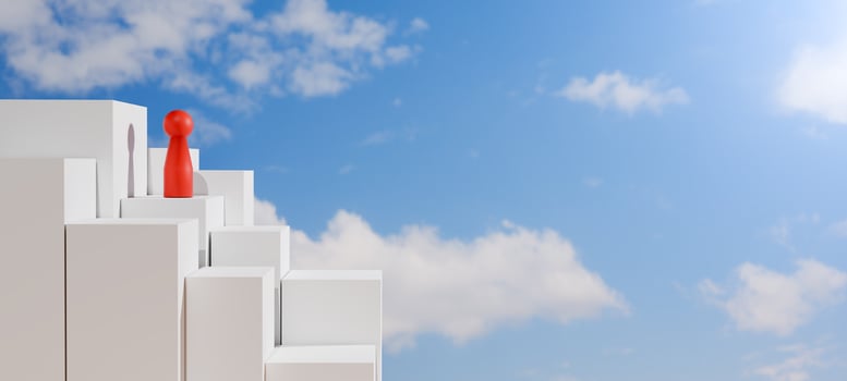 Red doll stands atop a white staircase reaching into a blue sky with clouds, symbolizing leadership, success, goal achievement, ambition, and overcoming challenges. photo