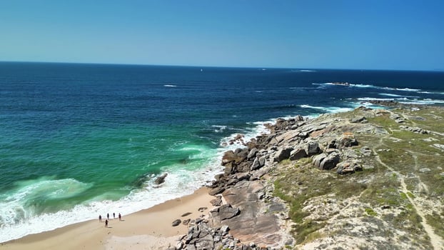 Experience the Stunning Coastal Views of the Serene Shoreline and Rugged Rocky Outcrops photo