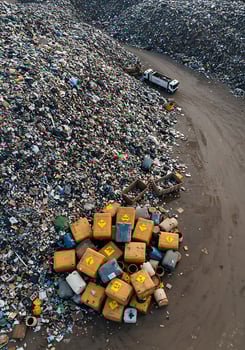 A truck is driving through a pile of garbage photo