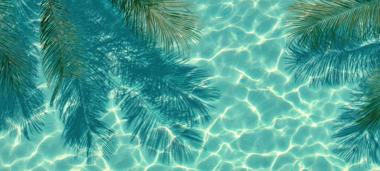 The tranquil turquoise water reflecting palm leaves in sunlight. photo