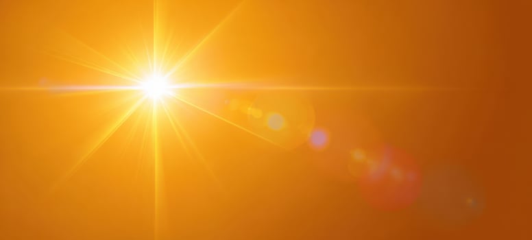 The radiant sun illuminating a warm orange sky at twilight photo