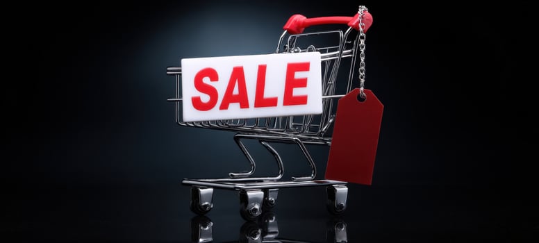 The shopping cart displaying a vibrant sale sign in a sleek studio setting. photo