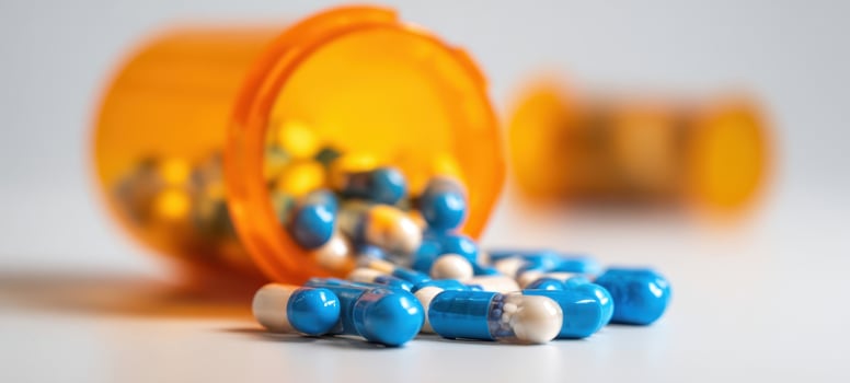 The colorful capsules spilling from an orange prescription bottle. photo